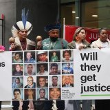Lundi, huit victimes avaient fait le déplacement, dont certaines en habits traditionnels agitaient devant le tribunal des maracas et interpellaient les passants au mégaphone, réclamant la "justice pour Mariana !". KEYSTONE/EPA/ANDY RAIN